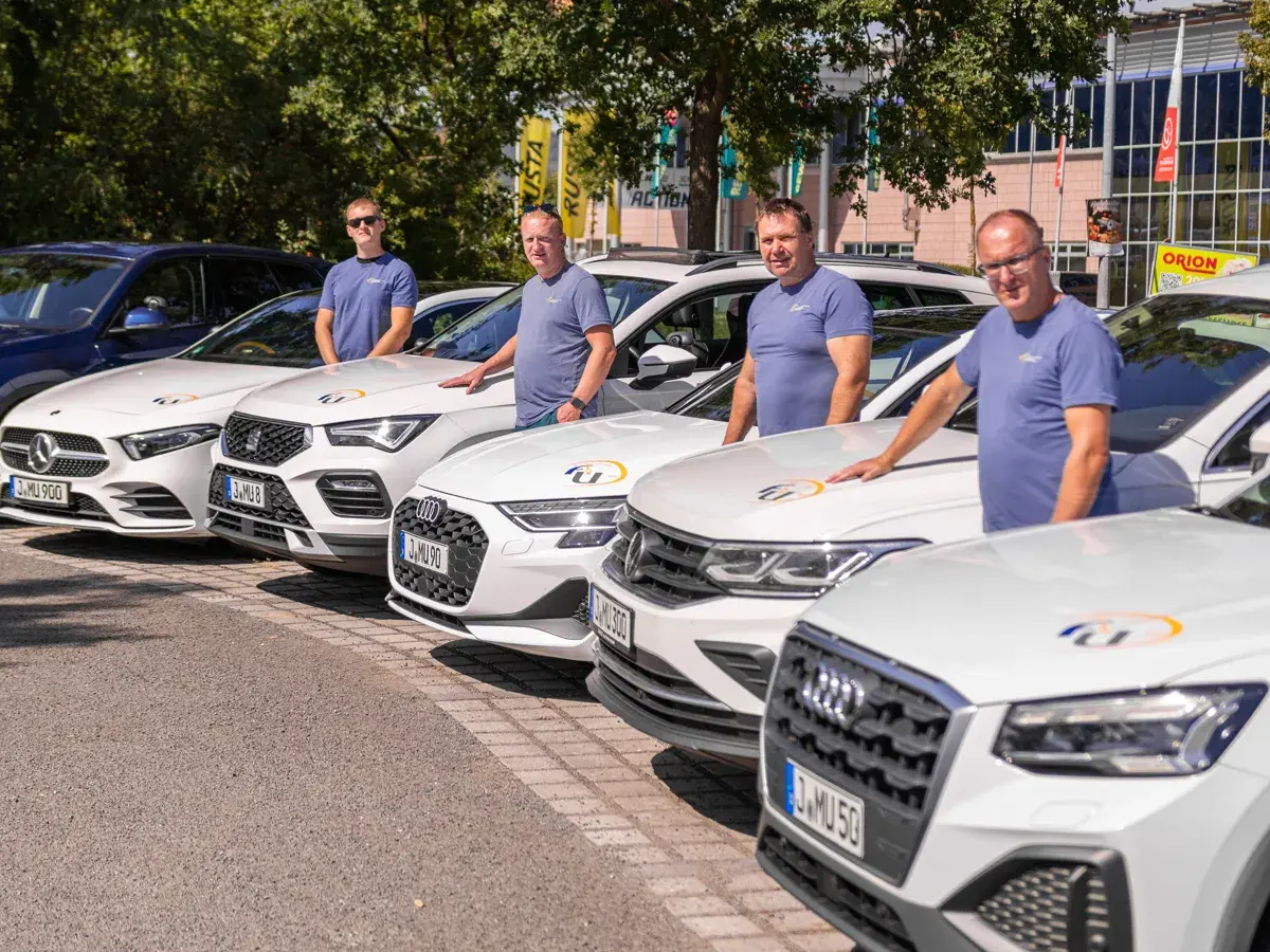 Fahrlehrer der Fahrschule Ukena an ihren Fahrzeugen